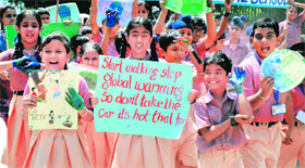 Schoolchildren hold a rally to raise awareness on global warming in Patiala on Tuesday.
