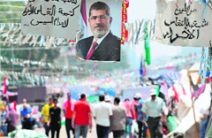 Mursis supporters walk past his portrait during a protest rally in Cairo on Tuesday.  AFP
