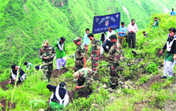Jawans of the Eco-Task Force and students plant saplings in Talogi village near Mussoorie on Wednesday. A Tribune photograph