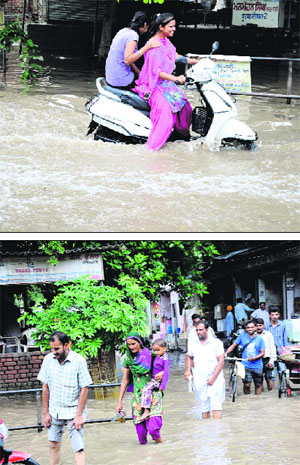  People wade through waterlogged areas of the city in Bathinda on Thursday.