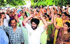 Members of the joint action committee of schoolteachers protest outside the DEO office at Sector 19 in Chandigarh on Thursday