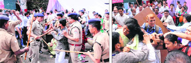 Policemen lathi charge members of the Panwar and Airy factions of the UKD; and (right) the members of the two factions battle for the control of the party office in Dehradun on Thursday. T