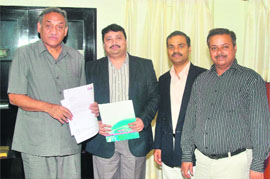 Prashant Sharma, head of HDFC Mutual Fund, presents a cheque for Rs 30 lakh to Chief Minister Vijay Bahuguna for disaster relief in Dehradun on Thursday.
