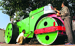 Railway employees give the finishing touches to a UK-made road roller, which is to be displayed at the entrance to the railway station in Ludhiana