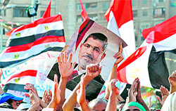 Supporters of deposed President Mohamed Mursi hold his portrait during a sit-in outside Cairos Rabaa al-Adawiya mosque on Wednesday. The presidency has called for peaceful protests on Friday urging Egyptians to empower the army