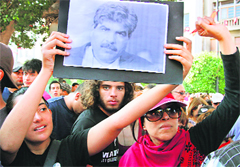 People take part in a rally after the assassination of leading opposition figure Mohamed Brahmi (portrait) in Tunis on Thursday.  AFP