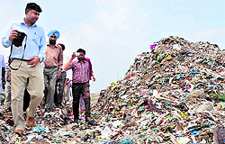 The local commissioner appointed by the National Green Tribunal, Ritwick Dutta (foreground), during his visit to the garbage dumping site on the Mansa road on Saturday