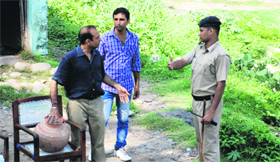 A policeman stops a man from immersing a pitcher in the Ghaggar