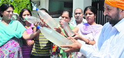 Residents of Vikas Nagar show the bottles filled with dirty water in Ludhiana on Saturday. Photo: Inderjeet Verma 