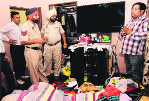 Policemen inspect the house where a theft took place in Sunny Enclave, Kharar, on Sunday. 