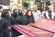 Muslim women look at the calligraphy art of the holy Koran at an exhibition in Dehradun on Saturday. 