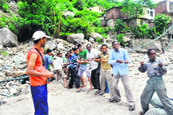 Villagers help erect a zipline trolley across a river near Augustmuni. 