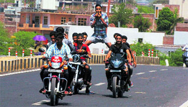 Youths throw caution to the wind as they perform motorcycle stunts at Bhagwati nagar in Jammu on Sunday. 