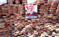 A poster of Mohamed Mursi with the slogan that reads No to the overthrow displayed on a makeshift brick barricade in Nasr City on Sunday