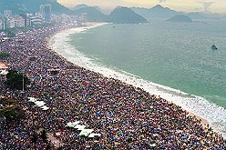 Catholic pilgrims attend World Youth Day and (right) Pope Francis waves at faithfuls at the Copacabana beach in Rio de Janeiro on Sunday
