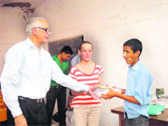 Members of Divine Light Trust gives course books to a student from Thatyur Government Inter-College on Mussoorie on Monday. 