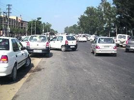 Vehicles parked haphazardly on a road outside a school on the Ludhiana-Ferozepur National Highway near Jagraon 