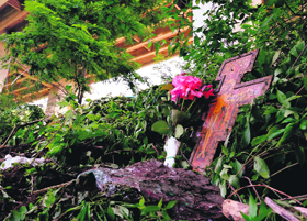 A cross and roses left among the wreckage of the bus at the accident site in Italy on Monday.