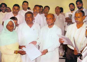 Chief Parliamentary Secretary Sultan Jadaula distributes cheques among beneficiaries under the Priyadarshani Aawas Yojna at Pundri on Tuesday