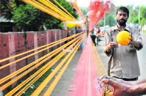 A man makes thread rolls for kites in Jammu.