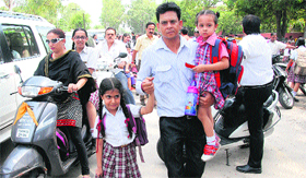 Parents accompany their children home after members of the School Auto Rickshaw Tempo Travel Mini Van Union kept their vehicles off road to protest against the district administrations policies in Jalandhar on Tuesday.