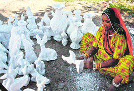  A woman makes earthen sculptures in Srinagar.