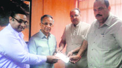 Amjad Ali hands over a draft to former president of the Rotary International Club, Raja K Saboo. 