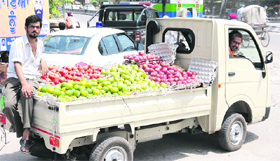 Vendors sell fruits on a vehicle on a hot summer day in Bathinda.