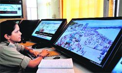 A policewoman monitors the movement of Kanwariyas through CCTC footages in Haridwar on Thursday. 