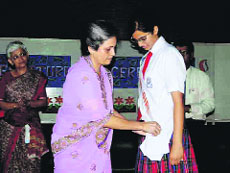 Anamika Pandey, head girl of Unison World School, being honoured by the principal in Dehradun on Thursday.
