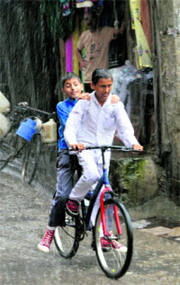 Students return from the school amid rain in Mandi on Thursday.