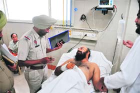 A policeman questions Taranjit Singh who was shot at in Noorwala village, Ludhiana