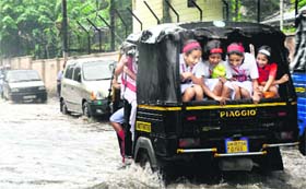 An auto-rickshaw carries schoolchildren in excess of the permissible number in Dehradun