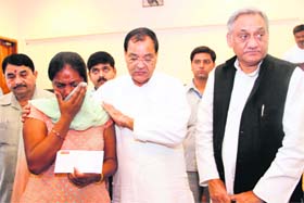 Chief Minister Vijay Bahuguna and Disaster Management Minister Yashpal Arya console a woman, who lost her kin in the natural disaster, after handing over the monetary relief cheque to her in Dehradun on Friday