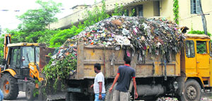 Safai karamcharis after withdrawing their strike start lifting garbage in Jalandhar on Friday.