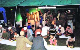 People have food during Iftaar party organised by the Army in Kishtwar on Friday