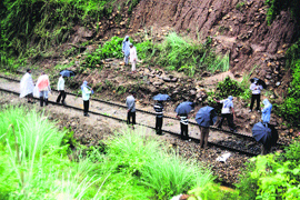 Labourers clear the railway track damaged due to a landslide near Samba in Jammu on Friday.