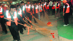 Employees of a Chandigarh-based sanitation company clean a road outside the Golden Temple during the launch of the night sanitation drive in Amritsar on Saturday. Photo: Sameer Sehgal