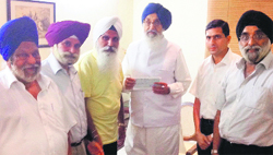 Members of Chief Khalsa Diwan present a cheque of Rs 10 lakh to Chief Minister Parkash Singh Badal. A Tribune Photograph 