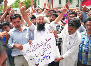 Contractual employees shout slogans in support of their demands for regularisation of jobs and hike in wages in Srinagar on Saturday.