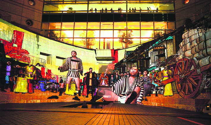 Computer graphic images are projected on the wall of a former dockyard in Yokohama, suburban Tokyo, for a press preview of a projection mapping of Yokohama history, “Yokohama Odyssey”.