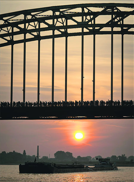 Participants walk over the Waal Bridge in Nijmegen, the Netherlands at dawn, during the International Four Day Marches of Nijmegen. Participants from over 60 countries take part in the event. 