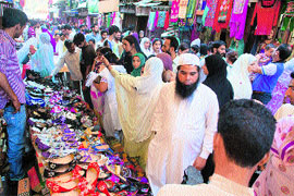 People purchase goods from a market ahead of Eid-ul-Fitr in Srinagar on Sunday. 