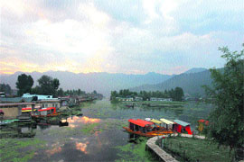 The morning sky reflects in the waters of the Dal Lake in Srinagar on Sunday.
