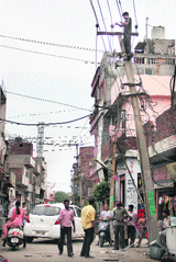 High-tension wires, passing over several buildings, being removed at Aman Nagar in Jalandhar on Sunday. 