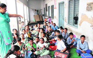 Students at Government Primary School, Tej Mohan Nagar, attend a class in the temple verandah