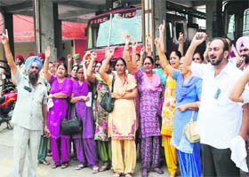 Aided school staff hold a protest against the state government demanding the release of their salaries at the Fire Brigade Chowk in Bathinda on Monday