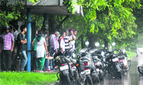 Residents wait for the rain to subside on Monday.