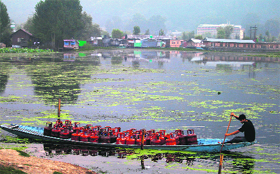A boatman carries LPG gas cylinders in his boat on the Nigeen Lake in Srinagar on Shab-e-Qadar on Monday.