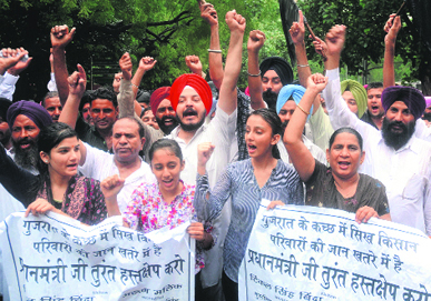 Members of the Indian National Sikh Youth Forum raise slogans against Gujarat Chief Minister Narendra Modi in Delhi on Monday.